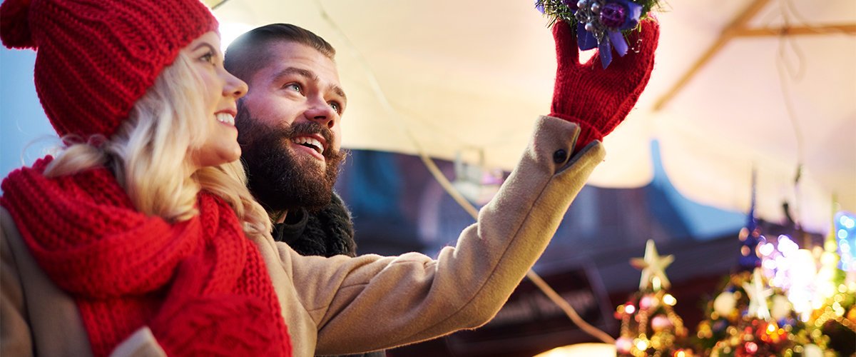 Couple putting up holiday decorations on patio